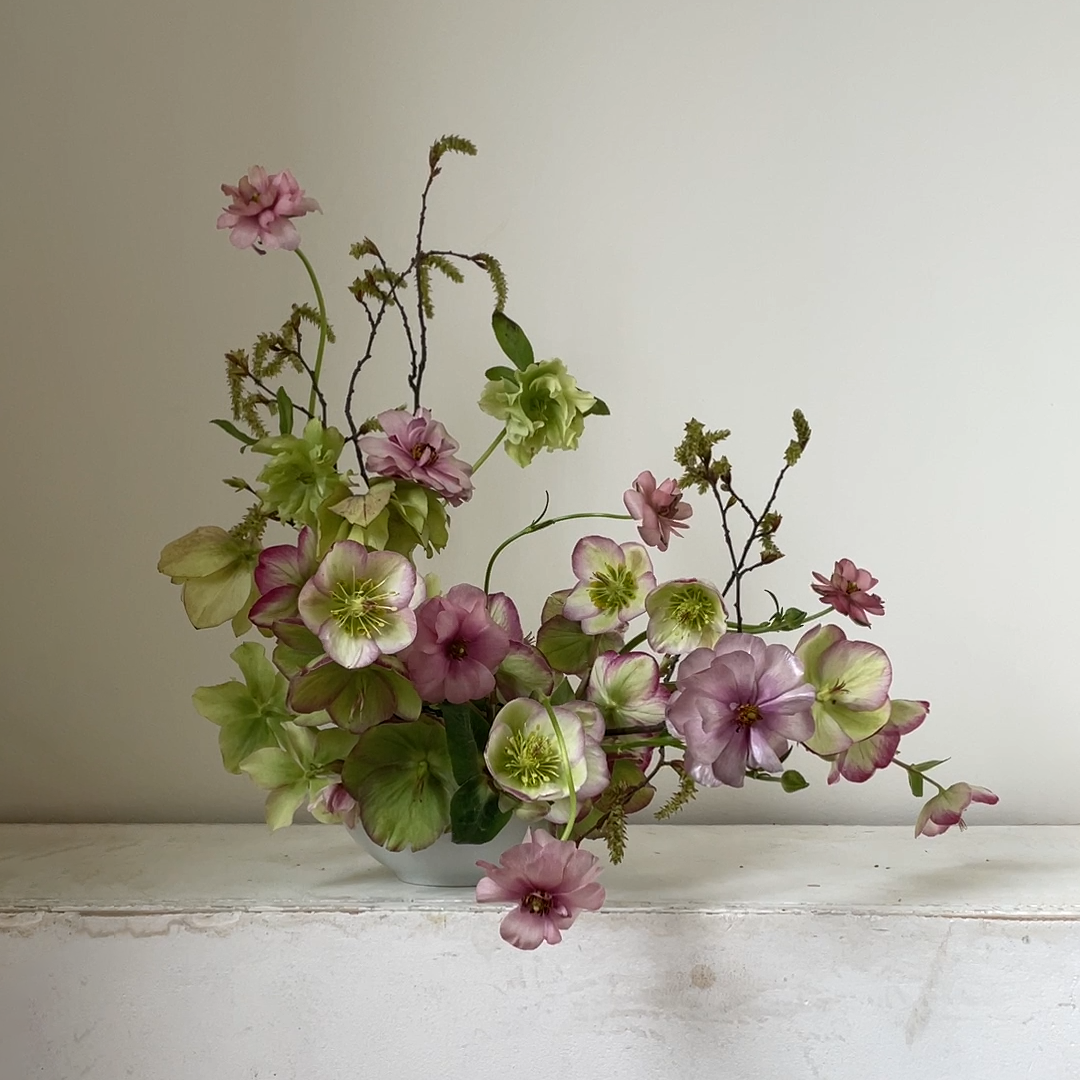 A sweet early spring combination of limey green and pink. Hellebores, butterfly ranunculus and catkins.   By Mora, a sustainable, season-led event florist based in Hackney, East London.