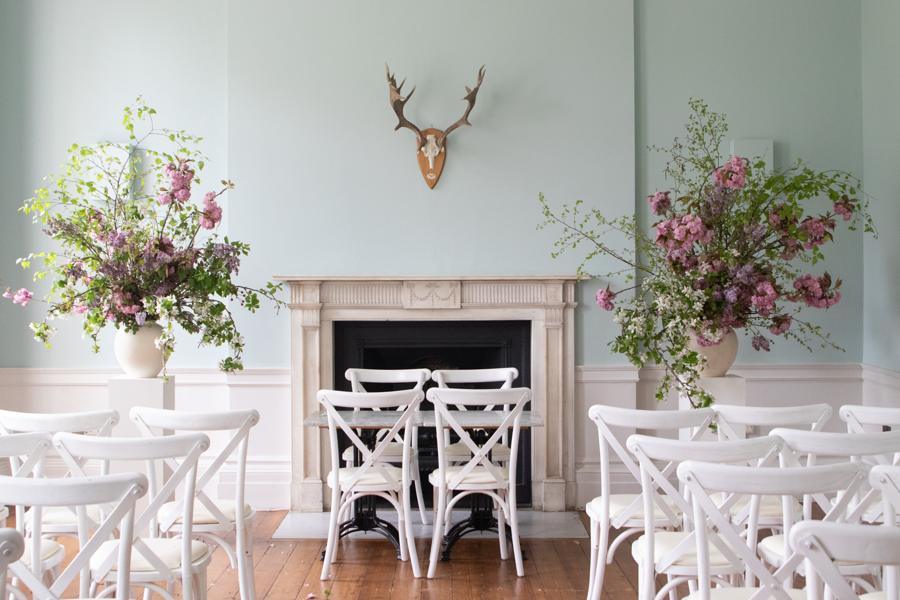 Fresh spring wedding urns. Beech foliage, soft lilac blooms, bouncy cherry blossom double blooms. By Mora, a sustainable, season-led event florist based in Hackney, East London.