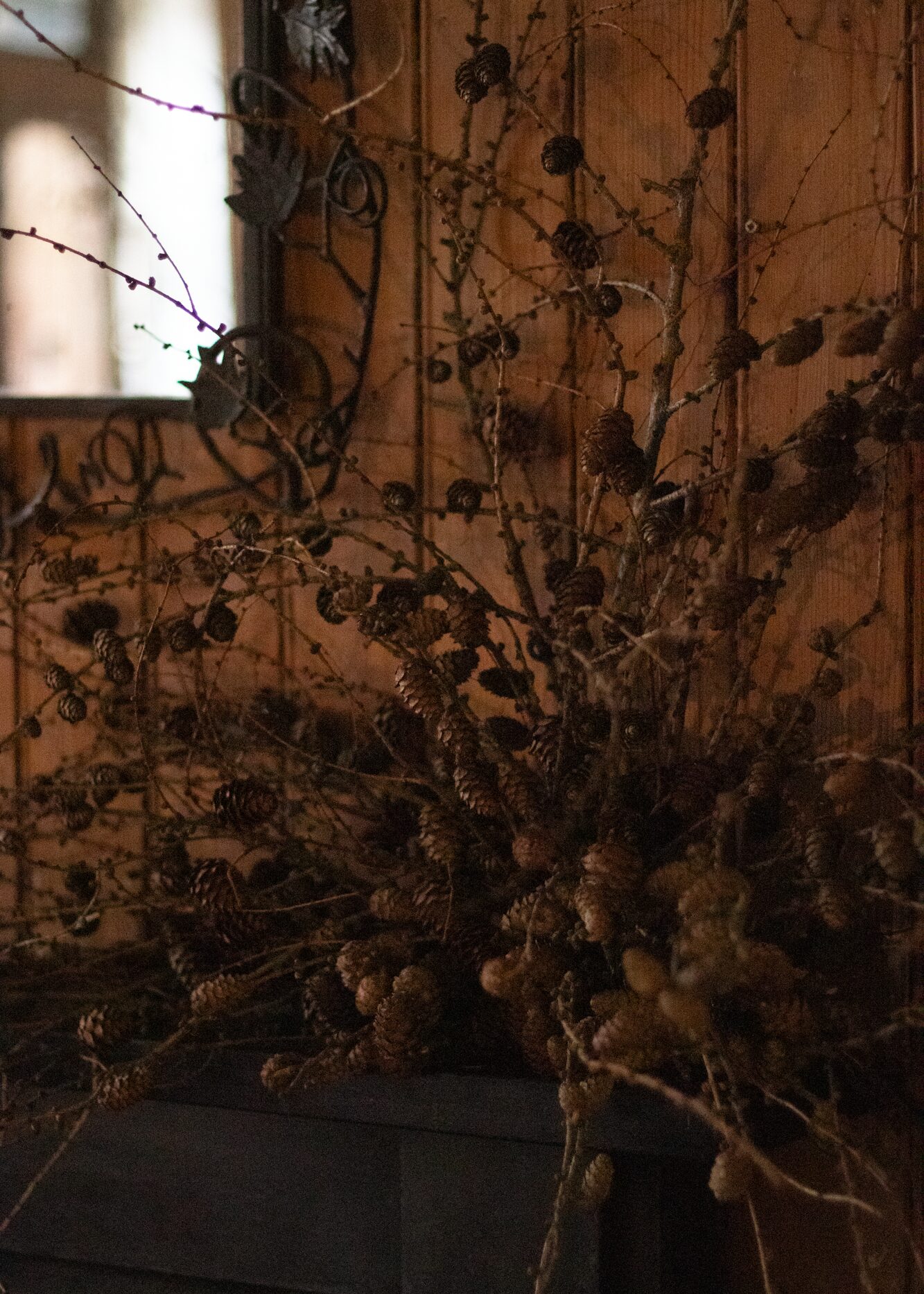 A tangle of larch twigs and cones, for a tonal woodland feel. By Mora, a sustainable, season-led event florist based in Hackney, East London